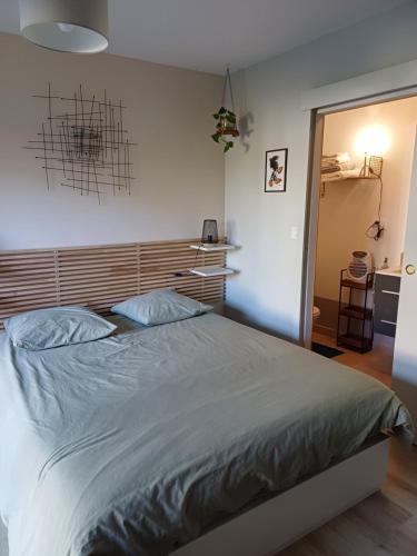 a bedroom with a large bed with a wooden headboard at Couettes et Mouettes in Lampaul-Plouarzel
