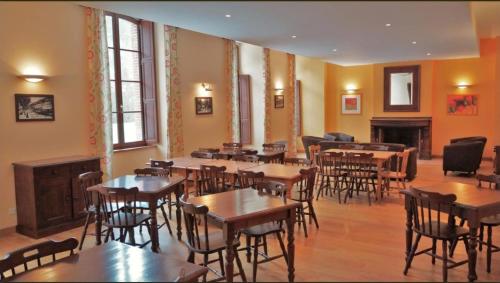un restaurant avec des tables et des chaises dans une salle dans l'établissement LA MARMOTTE appartement T2 classé 3 étoiles, à Aulus-les-Bains