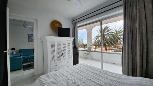 1 dormitorio con cama y vistas a un balcón en Apartamentos Tramuntana42, en Roses