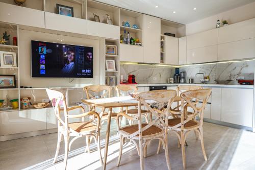 a kitchen with a table and chairs and a tv at Vila 29 Valamar in Durrës