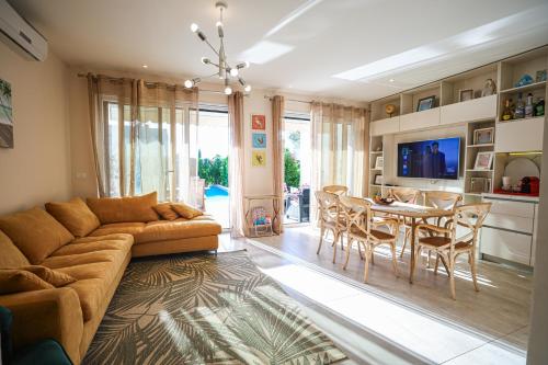 a living room with a couch and a table and chairs at Vila 29 Valamar in Durrës