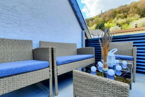a balcony with wicker chairs and a glass table at FeWo Schaumberg-Stübchen in Tholey