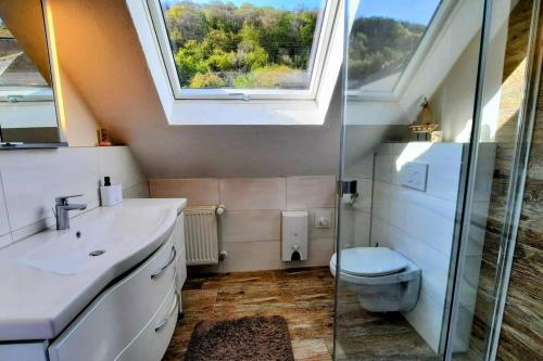 La salle de bains est pourvue d'un lavabo, de toilettes et d'une fenêtre. dans l'établissement FeWo Schaumberg-Stübchen, à Tholey