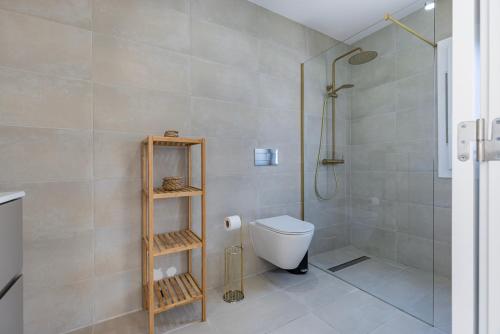a bathroom with a shower and a toilet in it at Poolside oasis by Caparica beach in Charneca