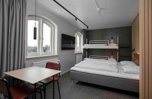 Zleep Hotel Køge في كوغ: غرفة نوم بسرير وطاولة وطاولة طعام