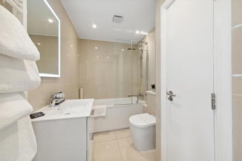 a white bathroom with a sink and a toilet at Nell Gwynn Chelsea Accommodation in London