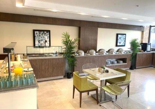 CoroEurobuilding Hotel & Suites Coro的有桌椅和柜台的餐厅