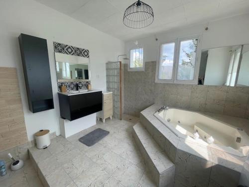 uma grande casa de banho com banheira e lavatório em Confort et Élégance 4 chambres parking privé gratuit em Bourges