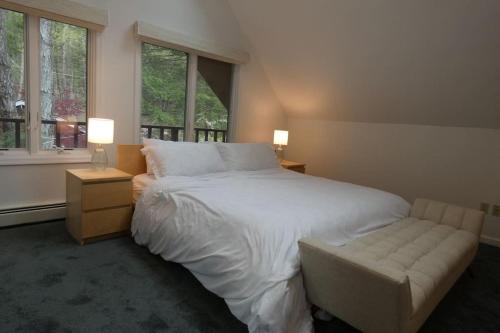 a bedroom with a large white bed and a window at Catskills Lakefront Escape with Hot Tub in Monticello