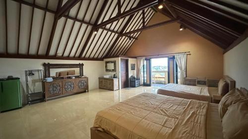 ジンバランにあるBukawa Lodge Jimbaranの大きなベッドルーム(大型ベッド1台、鏡付)