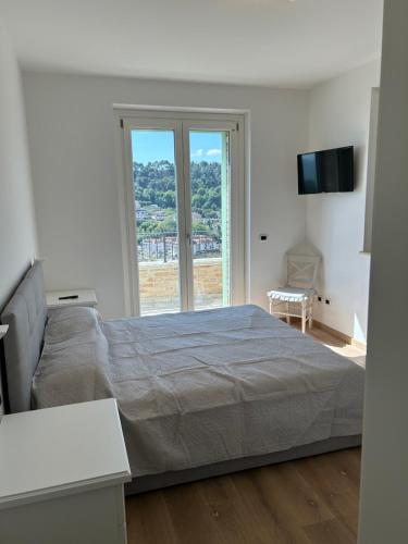 a bedroom with a large bed and a large window at Villa Colle dei Pini in Cupra Marittima