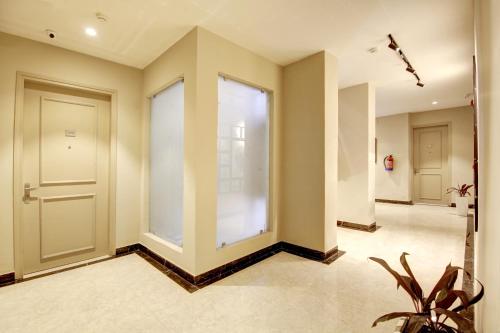 an empty hallway with a door and a plant at Saltstayz Horizon - Golf Course Road & Sector 29 in Gurgaon