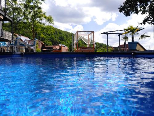 une grande piscine d'eau bleue à côté d'une aire de jeux dans l'établissement Aloha Annaberg, à Sulzbach-Rosenberg