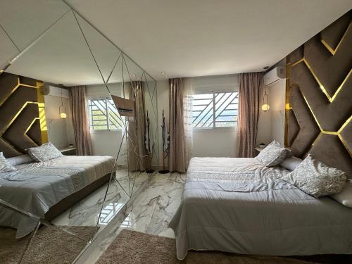 a bedroom with two beds and a mirror on the wall at Mandri apart in Tetouan