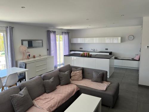 un salon avec un canapé et une cuisine dans l'établissement Villa Kaly,piscine privée plein sud, climatisation, internet, à Brouilla