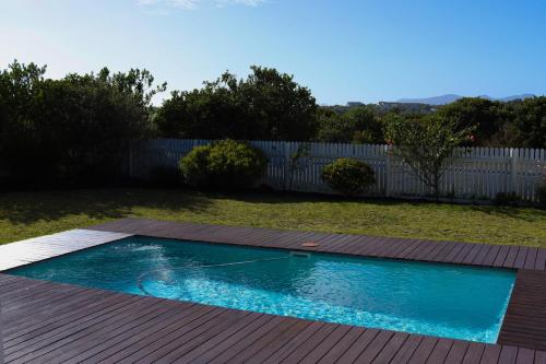 a swimming pool in a yard with a wooden deck at Ocean View - The Villa in Knysna