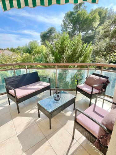 un patio con sillas y mesas en un balcón en Appartement Plage et Nature, en Saint-Raphaël
