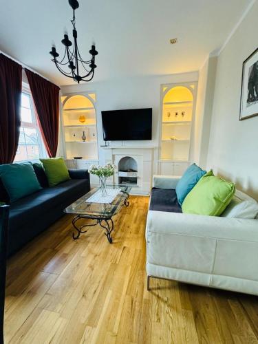 3 bed West Norwood Apartment في West Dulwich: غرفة معيشة مع أريكة وطاولة