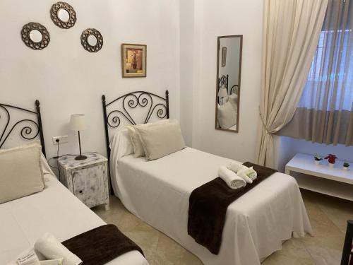 1 dormitorio con 2 camas y ventana en Esencia Andalucia en Rociana