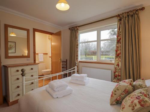 a bedroom with a bed with two towels on it at Tigh na Drochit in Glenelg