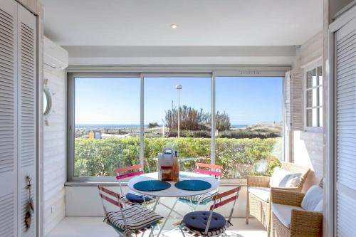 une pièce avec une table et des chaises et une grande fenêtre dans l'établissement Chez Danièle - Superbe studio avec une vue mer exceptionnelle, à La Grande Motte