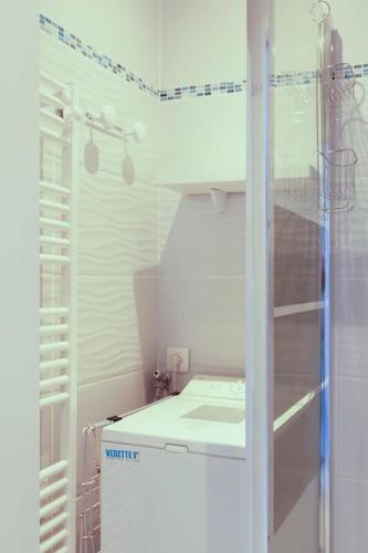 La petite salle de bains est pourvue d'un réfrigérateur et d'une douche. dans l'établissement Chez Danièle - Superbe studio avec une vue mer exceptionnelle, à La Grande Motte