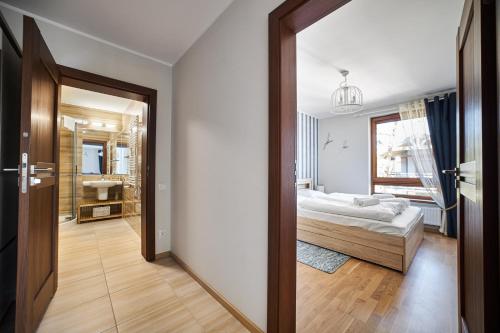 a bedroom with a bed and a bathroom at Rezydencja Park Mielno in Mielno