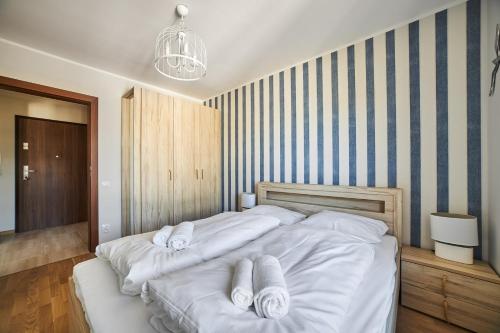 a bedroom with a large white bed with towels on it at Rezydencja Park Mielno in Mielno
