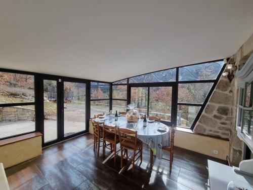 d'une salle à manger avec une table et quelques fenêtres. dans l'établissement La Mordorée, maison ancienne jacuzzi, à Rivière-sur-Tarn