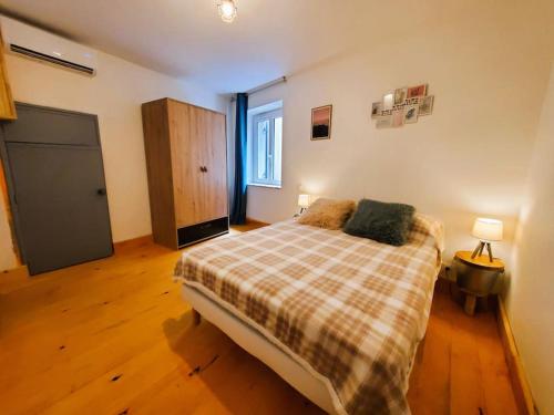 - une chambre avec un lit et une couverture en damier dans l'établissement Appartement climatisé avec extérieur à Sarlat, à Sarlat-la-Canéda