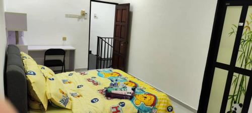 a bed with a yellow comforter with a train on it at ankang in Alor Setar