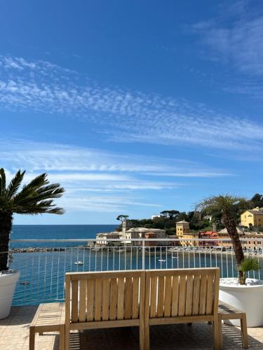 a wooden bench sitting on a balcony overlooking the ocean at Hotel Helvetia in Sestri Levante