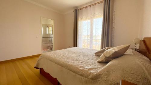 a bedroom with a bed with a large window at Lolik Villa in Sobreda