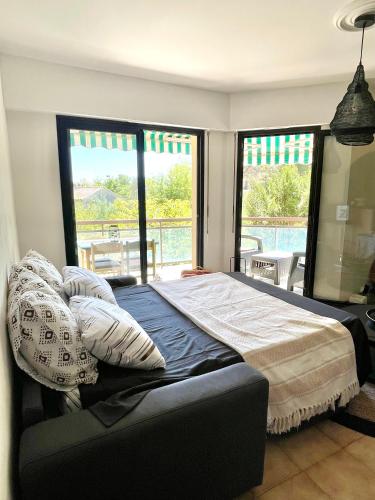 1 dormitorio con cama con almohadas y balcón en Appartement Plage et Nature, en Saint-Raphaël