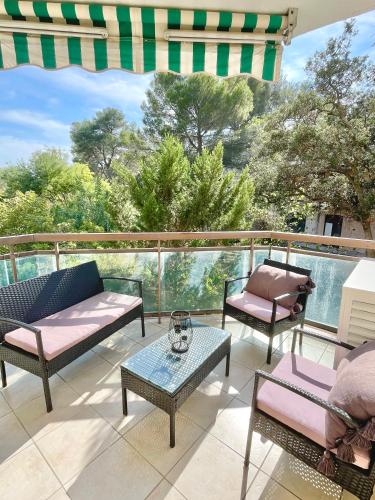 d'une terrasse avec des chaises et des tables sur un balcon. dans l'établissement Appartement Plage et Nature, à Saint-Raphaël