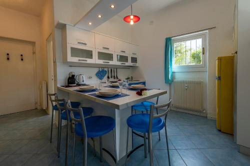 a kitchen with a large island with blue chairs at Emma's House in Lierna