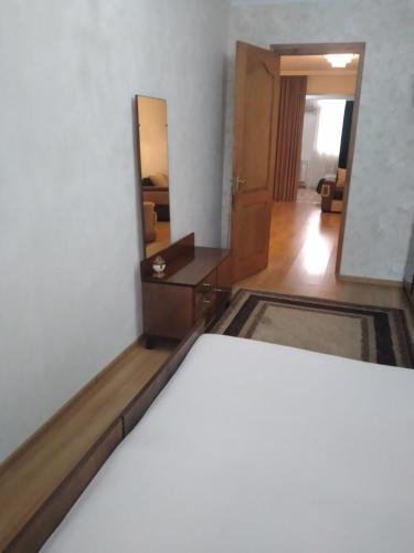 a room with a bed and a mirror at Izi's cozy apartment in Kutaisi