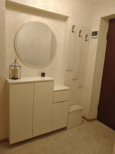 a bathroom with white cabinets and a mirror at Izi's cozy apartment in Kutaisi