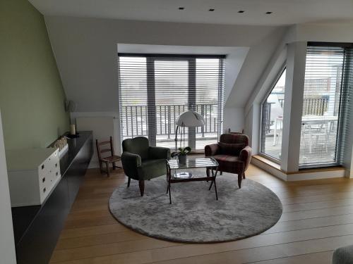 sala de estar con mesa, sillas y ventanas en Business Accommodation 'Flow' Nomad, en Geel