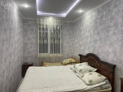 1 dormitorio con cama y techo en Yunusabad 15, Tashkent, en Tashkent