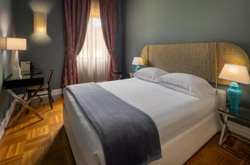 a bedroom with a large white bed and a desk at Hotel Number Nine in Florence