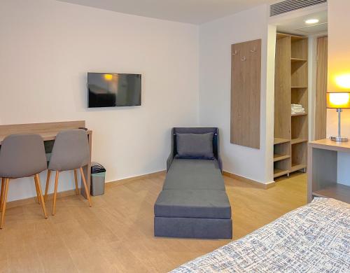 um quarto com uma cama, uma mesa e cadeiras em Aurora Rooms - 290m from Aqua Park em Băile Olăneşti