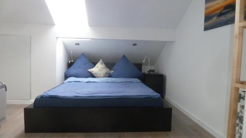 萬格爾蘭的住宿－Ferienwohnung Dünenblick，一间卧室配有一张带蓝色床单和枕头的床。