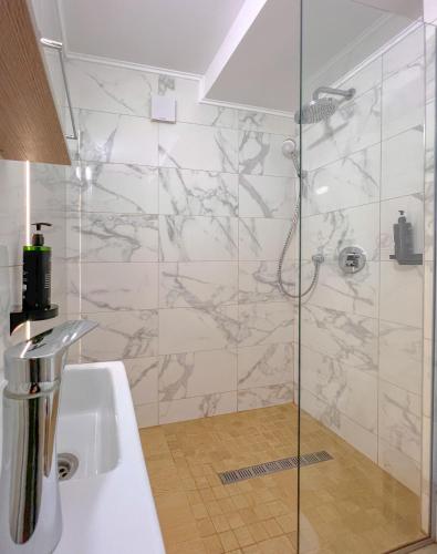 a bathroom with a shower and a sink at Hotel Aurora in Băile Olăneşti