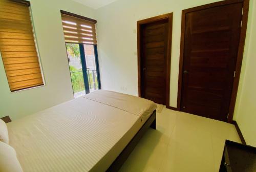 キャンディにある`Kandy Lake Round Apartmentの窓とドアが2つあるドミトリールームのベッド1台分です。