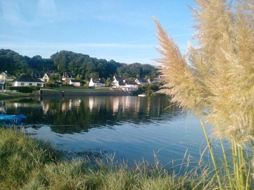 - une vue sur un lac avec des maisons en arrière-plan dans l'établissement La maison du Lenn face à la mer, à Louannec