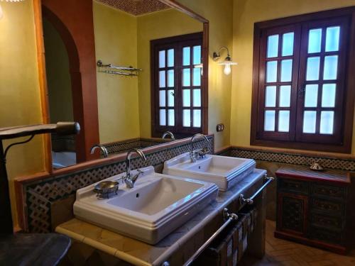 La salle de bains est pourvue de 2 lavabos et d'un grand miroir. dans l'établissement Andalusische Villa, à Mairena del Aljarafe