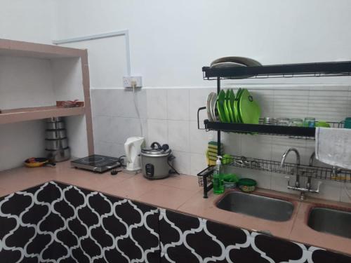 - une cuisine avec un évier et un comptoir dans l'établissement DIAMOND HOMESTAY, à Kuala Kangsar