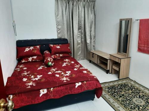 - une chambre avec un lit et une couette rouge dans l'établissement DIAMOND HOMESTAY, à Kuala Kangsar