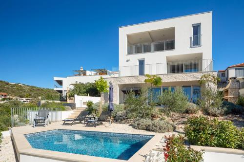 una imagen de una casa con piscina en Villa CapeCarol, en Rogoznica